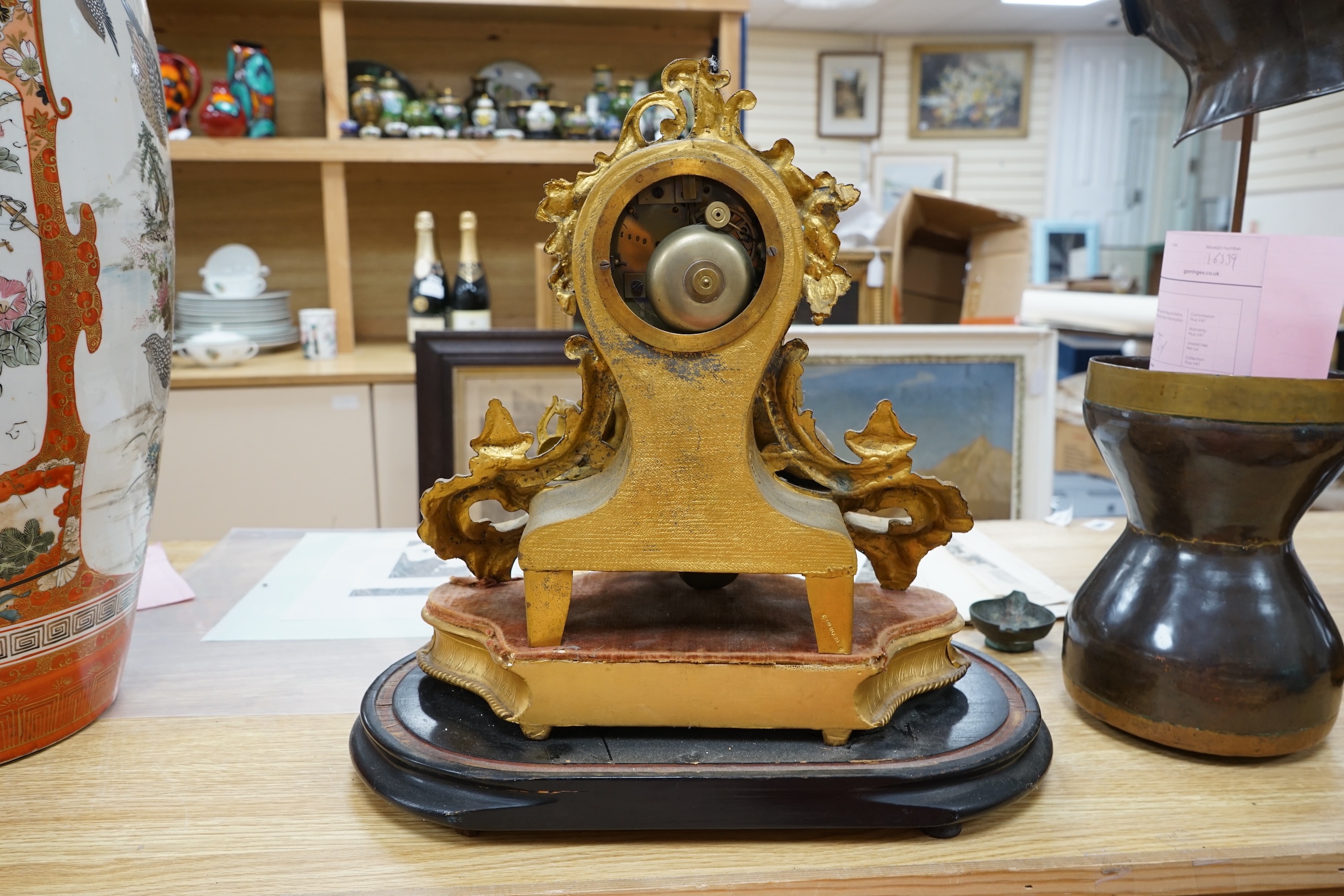 A 19th century French, Rococo Revival gilt metal figural mantel clock, striking on a bell, raised on gilt wood plinth, no key, 41cm high. Condition - fair, untested